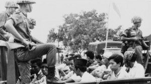 Anggota divisi pemuda Partai Komunis Indonesia (PKI) dijaga oleh tentara saat dibawa dengan truk ke penjara di Jakarta, 30 Oktober 1965. (Foto: Dok)